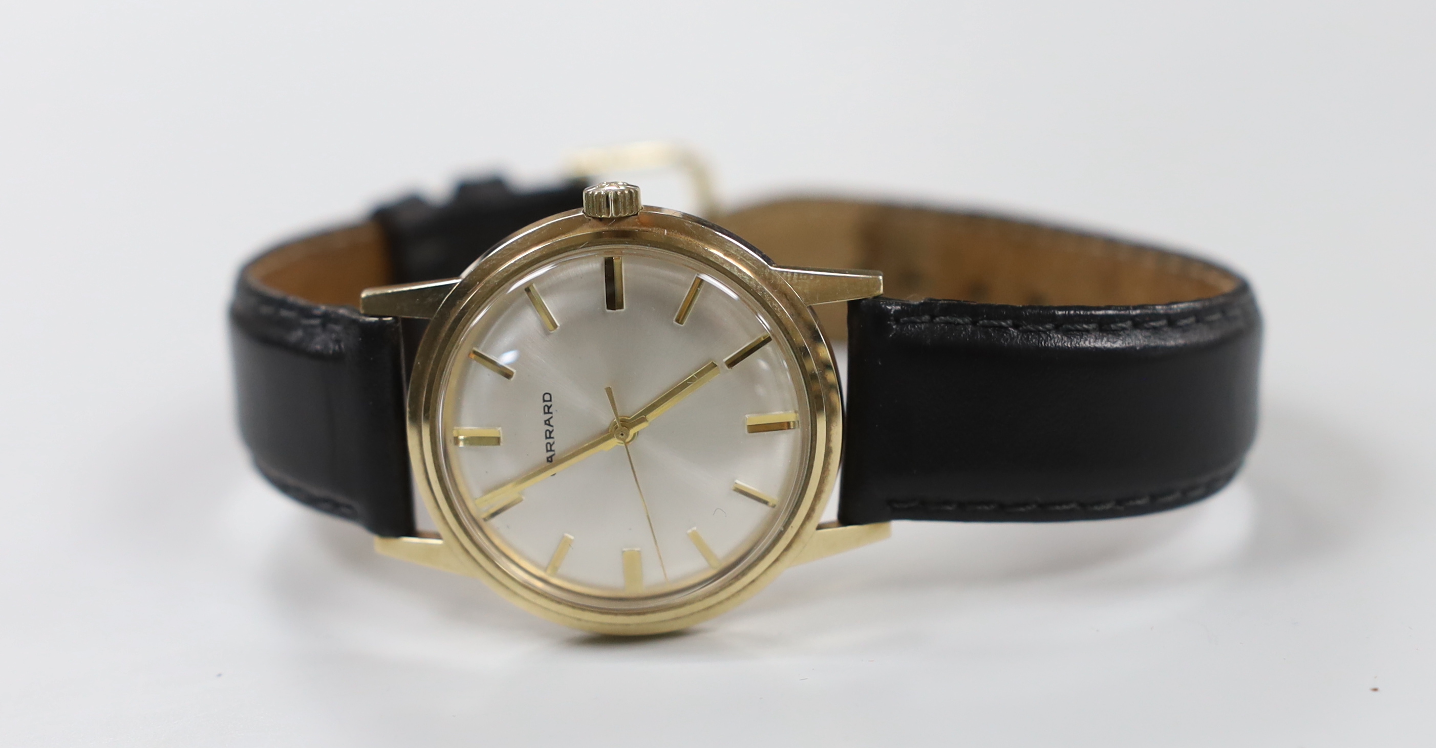 A gentleman's early 1970's 9ct gold manual wind wrist watch, retailed by Garrards, with case back inscription, on a leather strap.